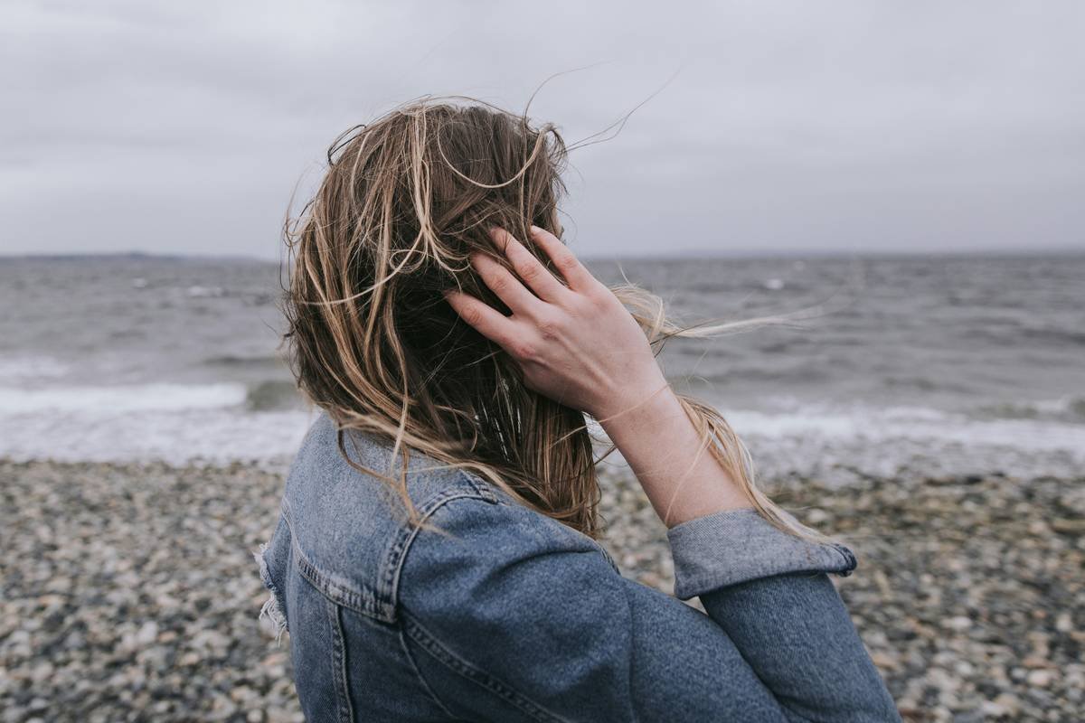 Woman with hand in hair looking at the water