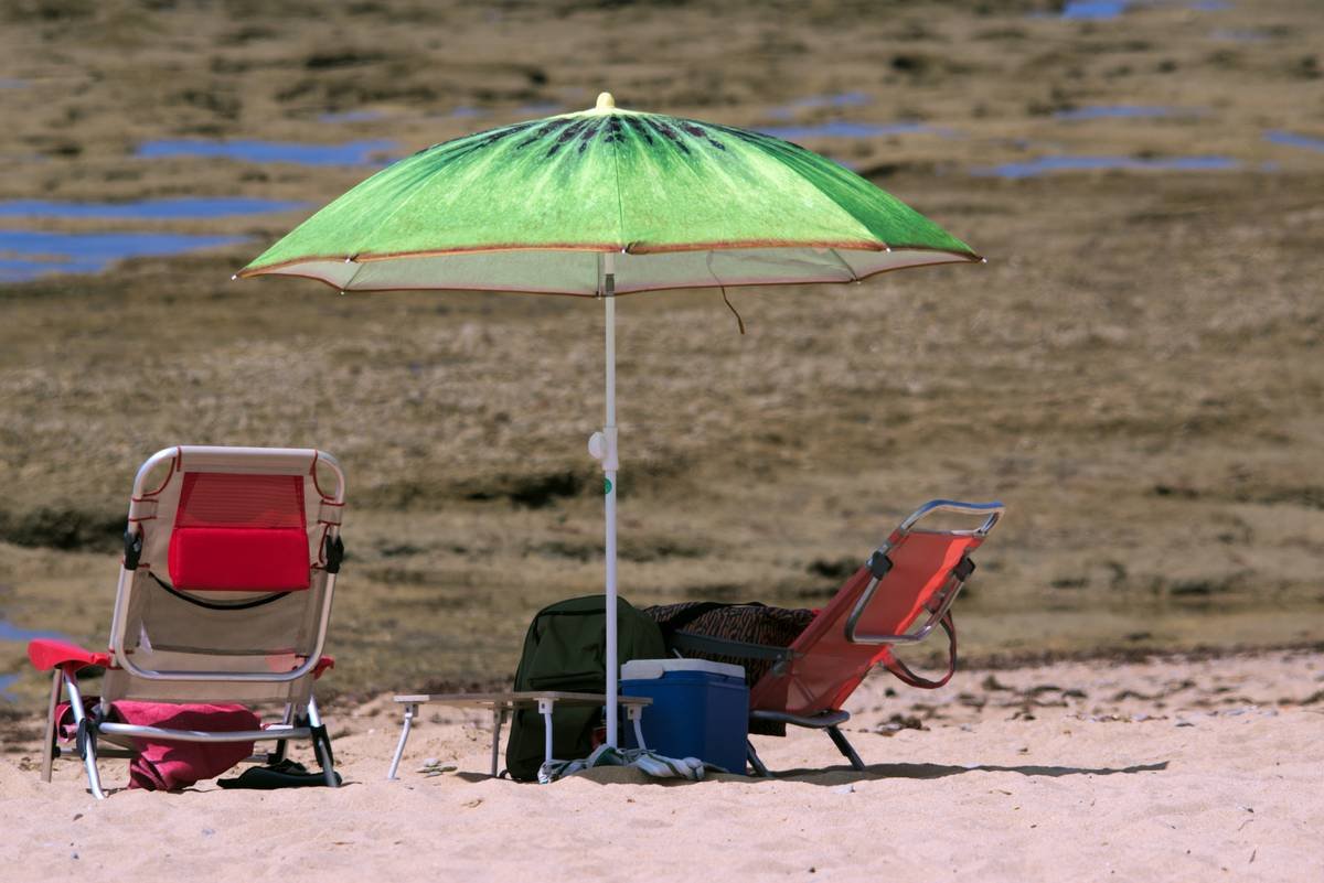 Infographic showing UV ray reflection off sand and how integrated beach chair umbrellas block both direct and reflected sunlight