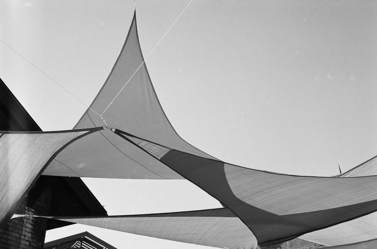 Side-by-side comparison: flimsy beach umbrella vs. reinforced patio shade beach umbrella showing pole thickness, vented canopy, and base weight
